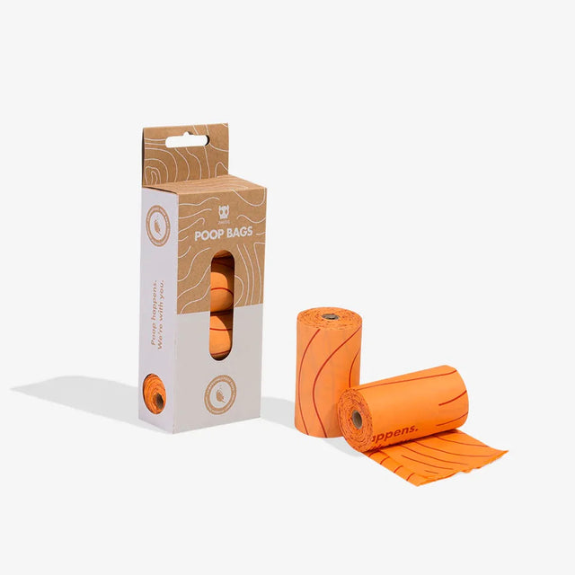 A pack of orange dog waste bags with citrus scent, displayed alongside two rolls of the bags outside the packaging.