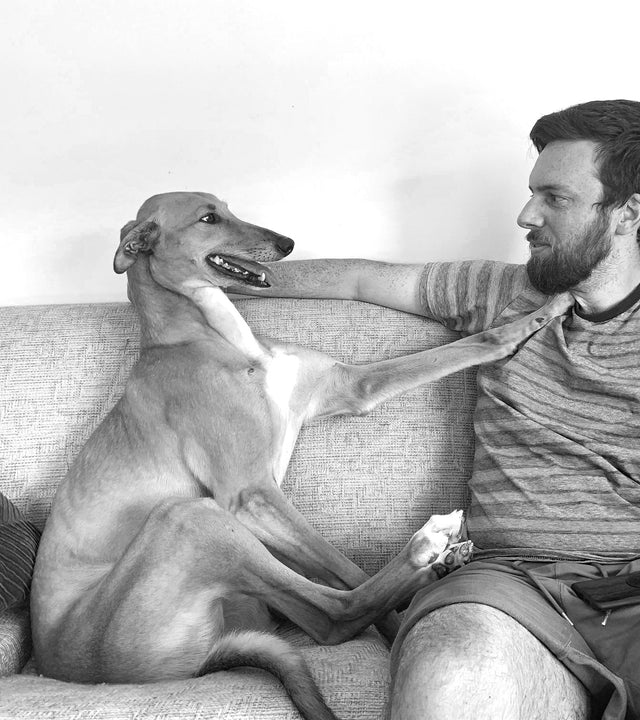 a man with his best friend Teddy who is a retired racing greyhound
